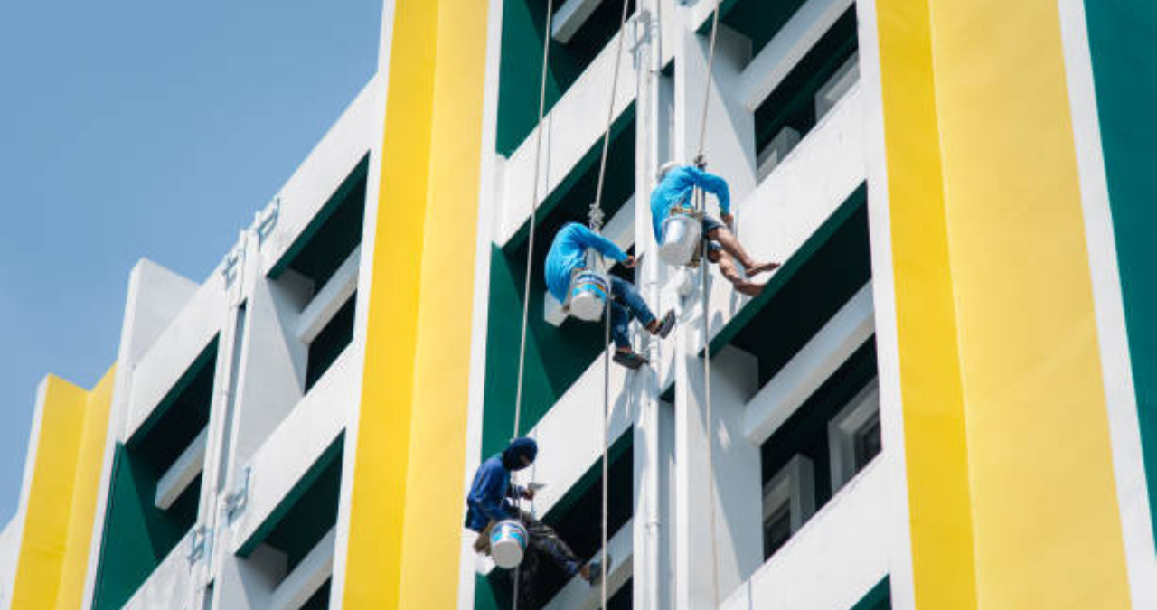 Maintenance workers painting a high-rise building exterior - Maintenance for buildings